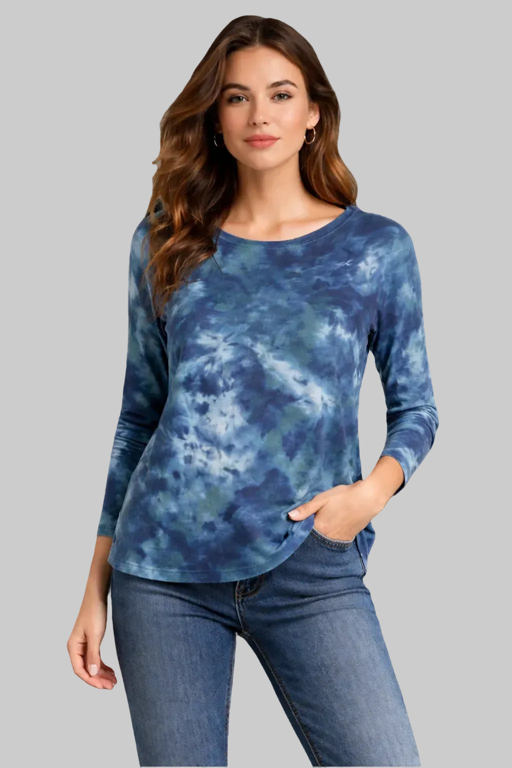 Woman wearing a blue tie-dye long-sleeve top and jeans on a gray background