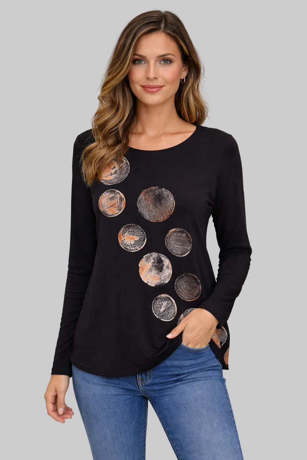 Woman wearing a black long-sleeve top with circular designs against a plain background