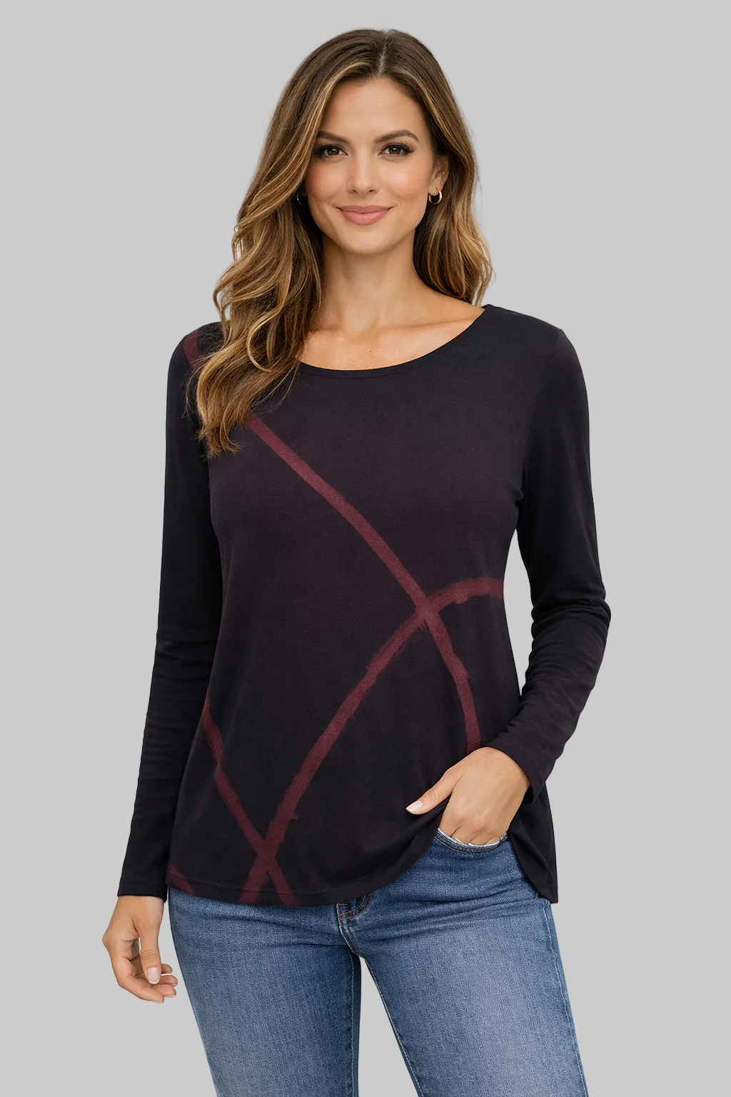 Woman wearing a black long-sleeve top with a red abstract design, standing against a white background.