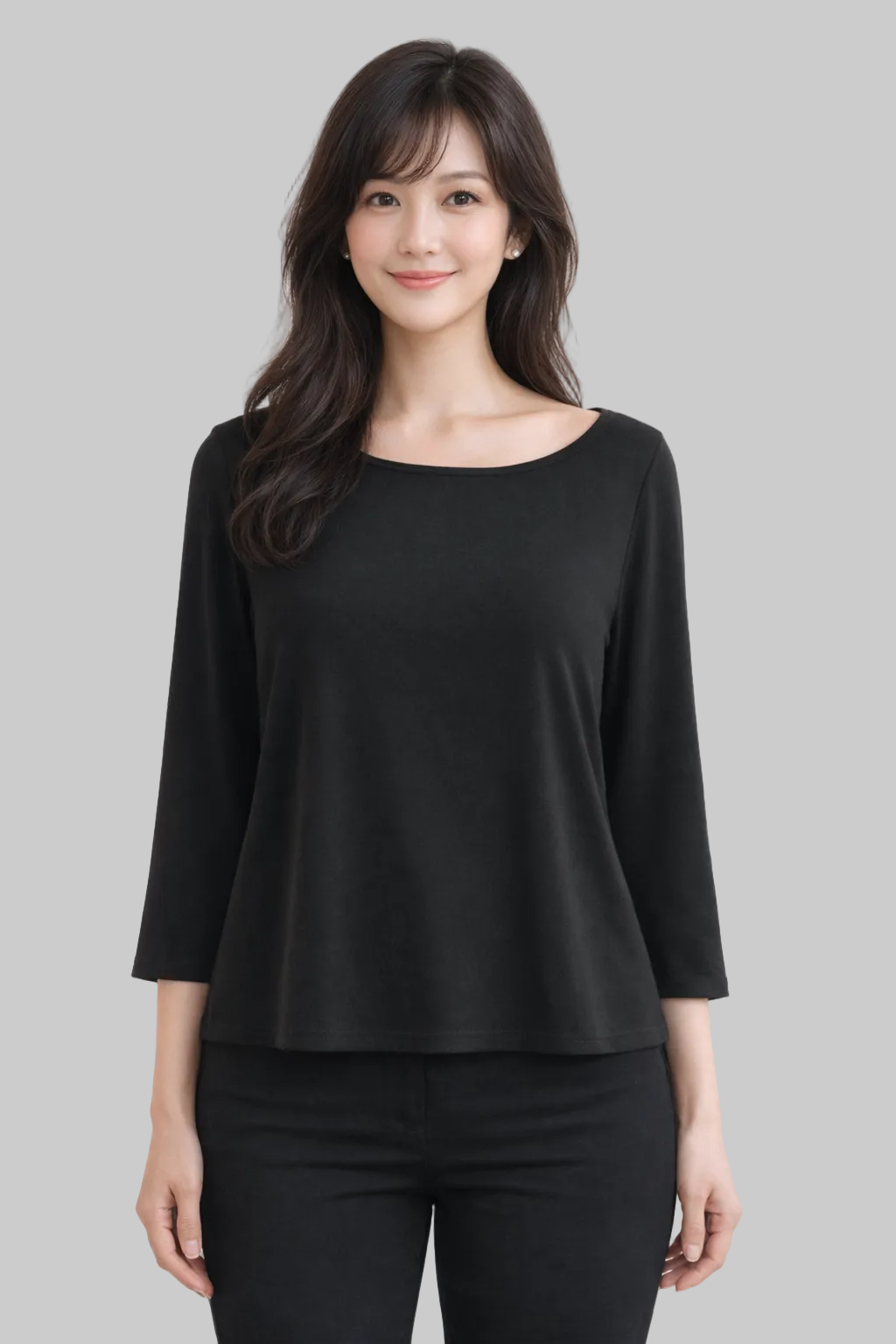 Woman wearing a black top and black pants against a white background