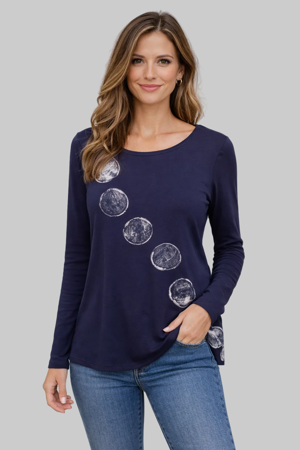 Woman wearing a navy long-sleeve top with moon phase designs on a plain background