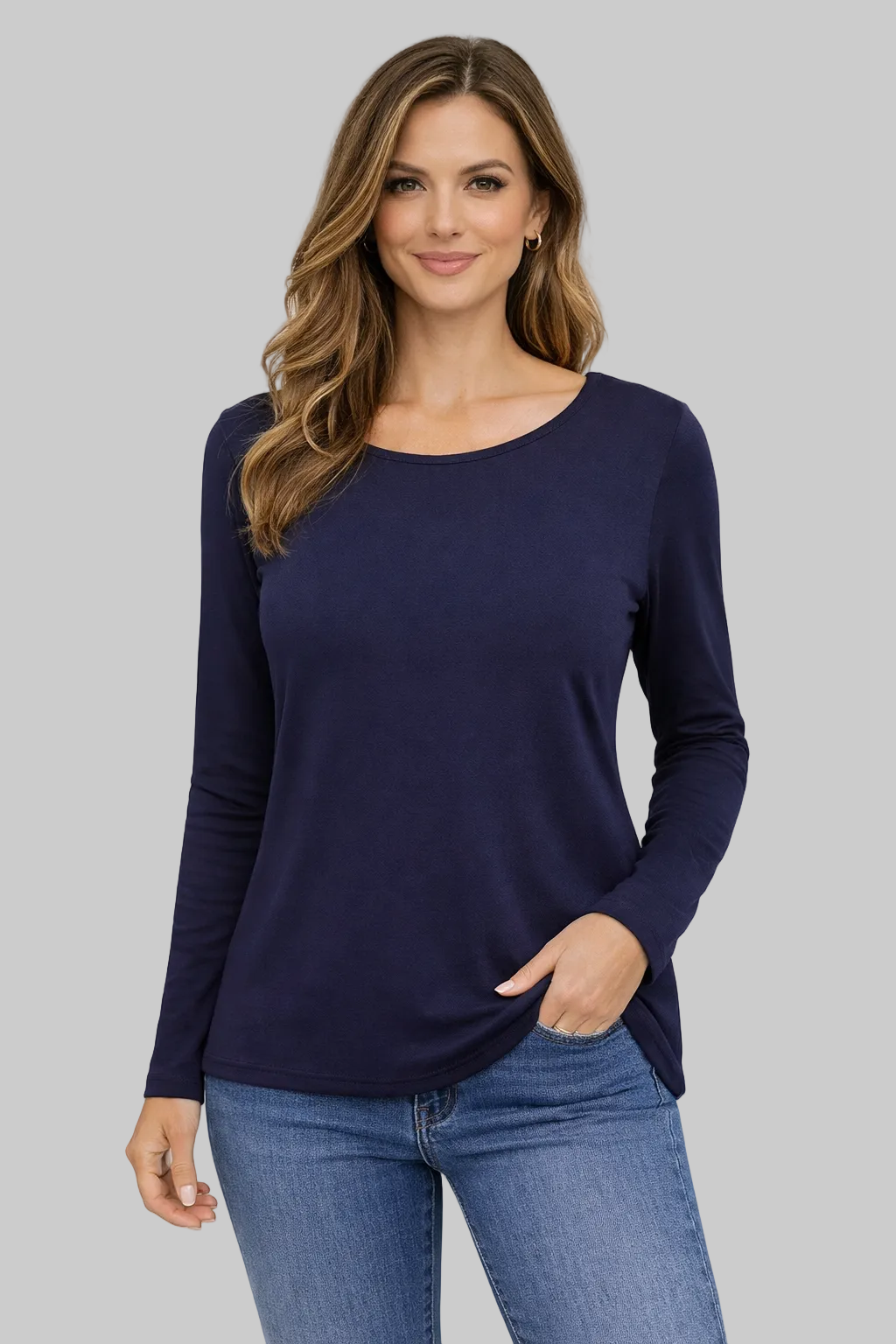 Woman wearing a navy long-sleeve top and blue jeans on a white background